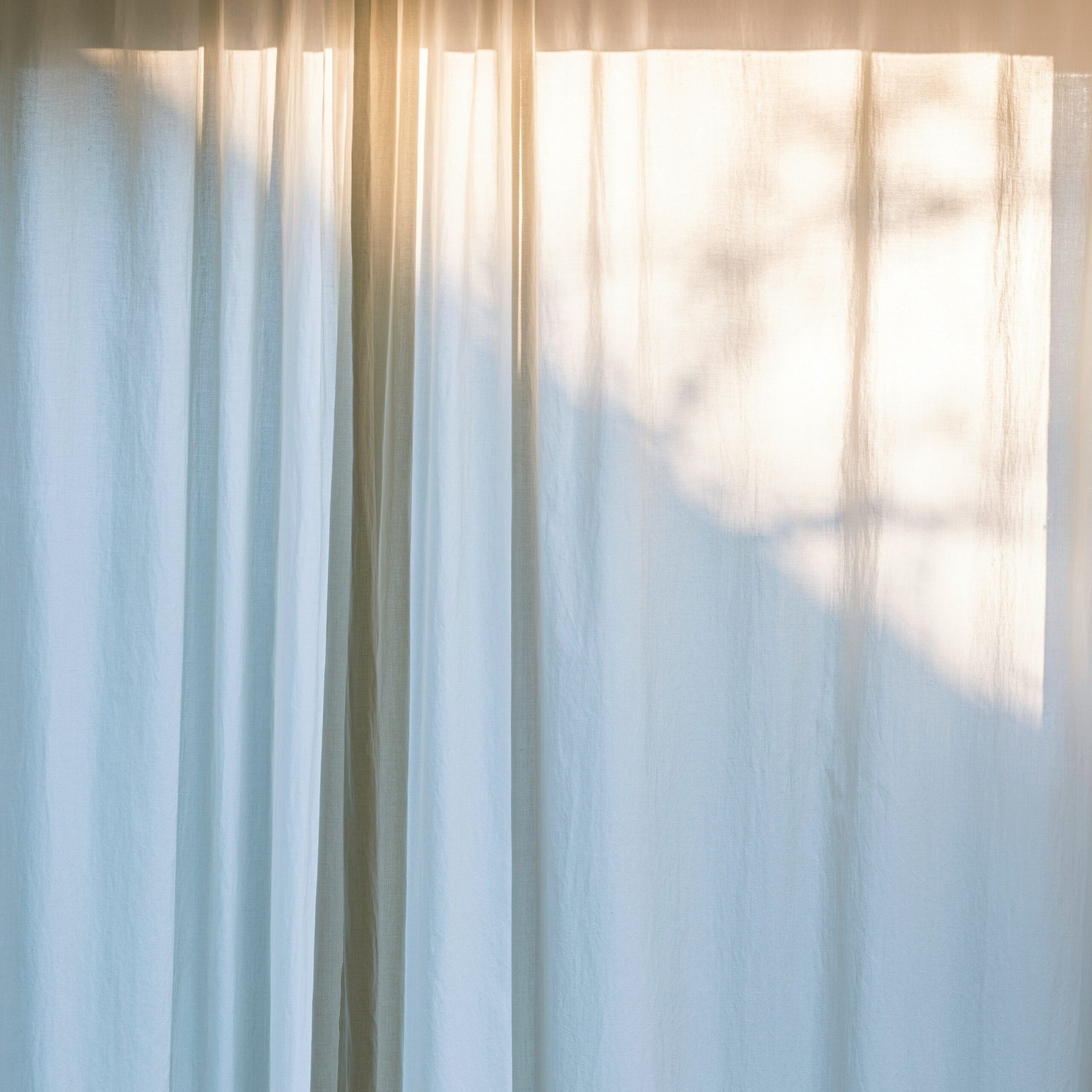 Soft morning light through sheer curtains