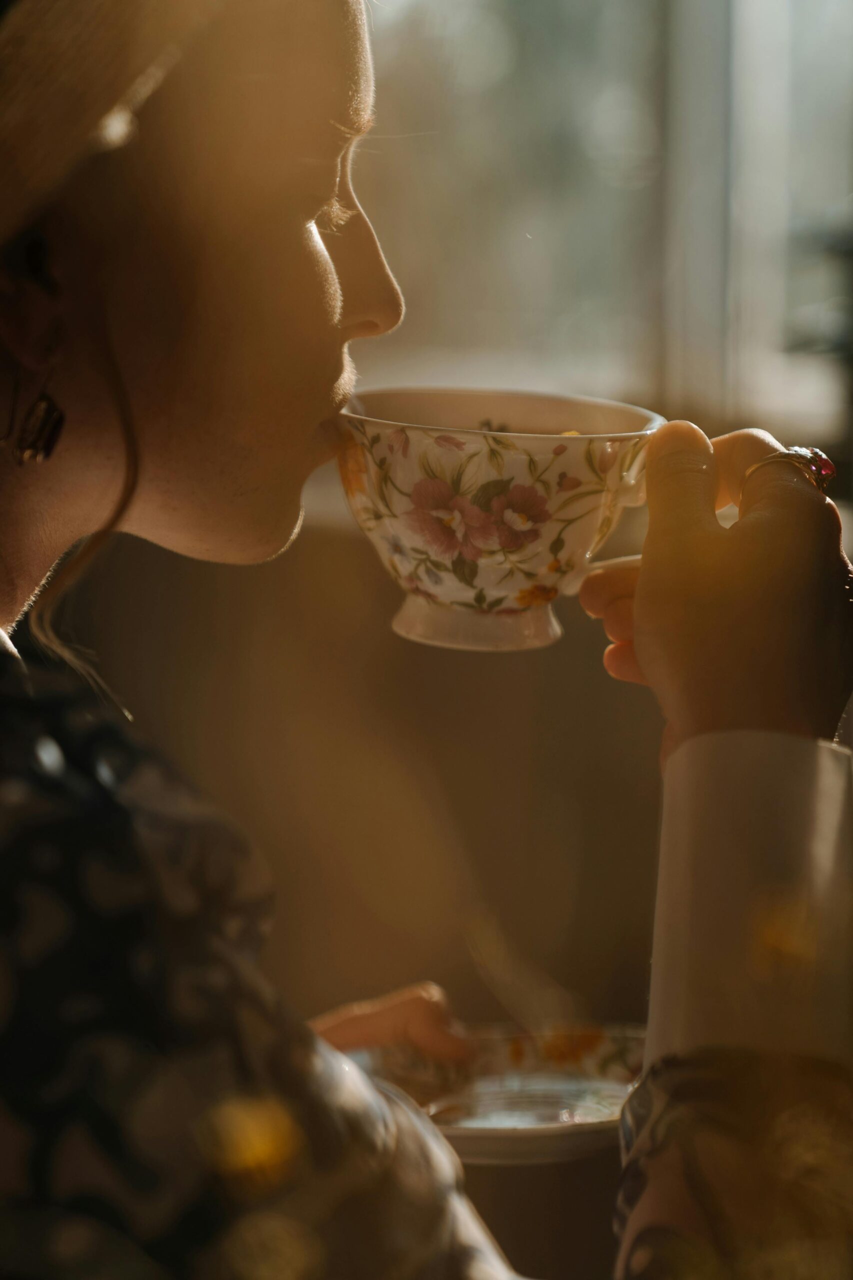 Woman taking a quiet moment with a cup of tea in warm morning light