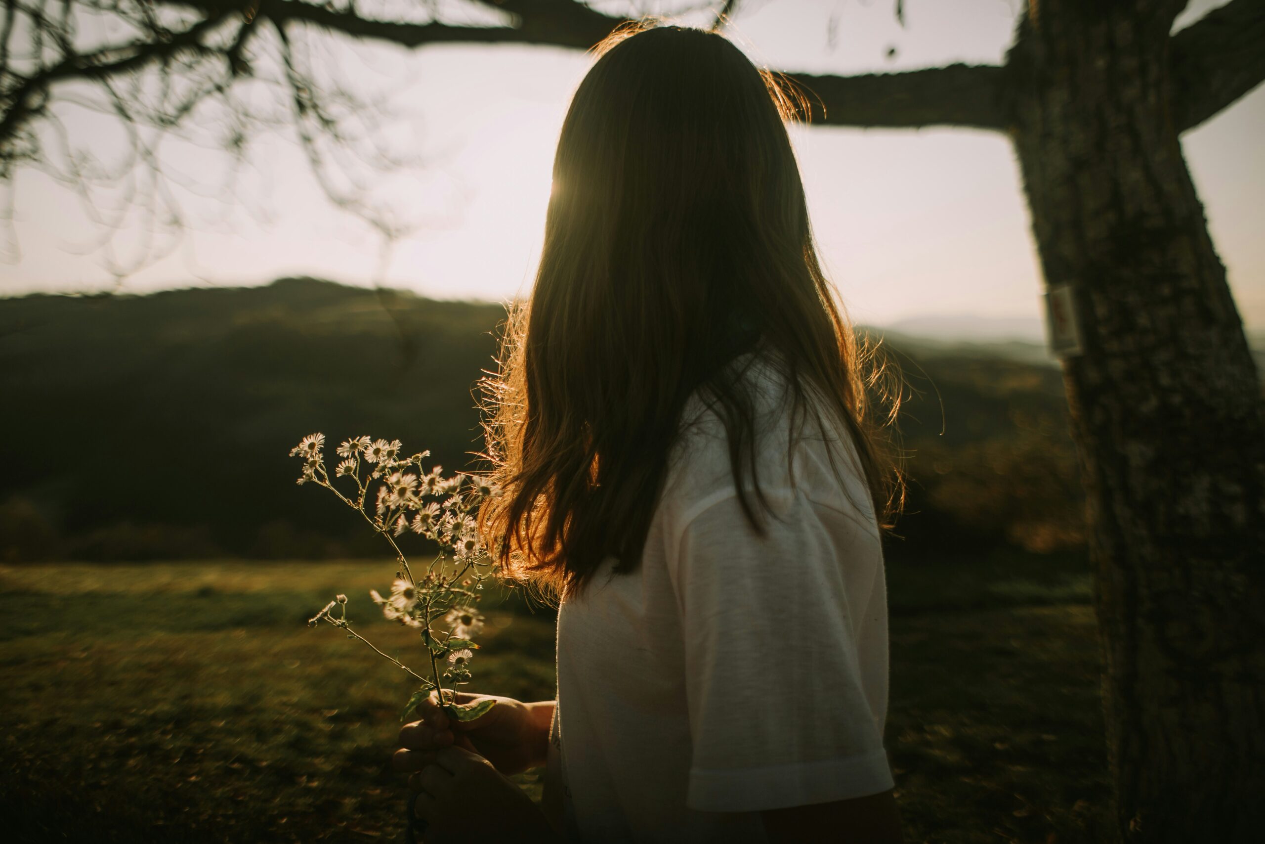Woman holding wildflowers in golden evening light
